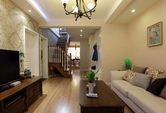 客厅，米白色的墙面多了一份温柔的触感，从客厅这里就可以看到去二楼的楼梯。