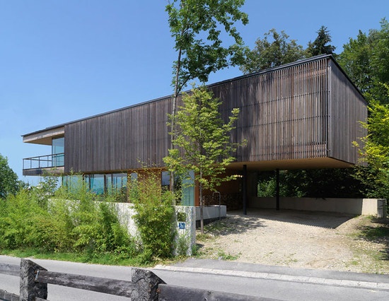 haus am felsen，翻译为岩石上的房子，是由布雷根茨的 elmar ludescher 建筑事务所设计的双悬臂结构，坐落于峡谷之上，尽享附近湖泊和下方城市的美景。住宅被构思为一个镜头，透过它可以观看周围的景观。一层的玻璃和钢结构基础使内外连通，得益于地面的植物，自然地保护了私密性。在基础之上，木质的体块悬落在峡谷之上，并在另一端形成一个车库。