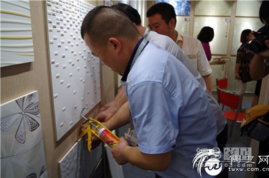 4月18日，随行工作人员撬开方瑞陶瓷展示墙上涉嫌盗用的瓷片（图片来源：陶卫网）
