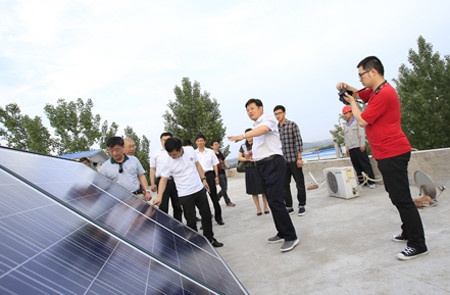 王贵富（前排右二）向国家林科院有关领导、专家学者汇报太阳能干燥设备生产情况。