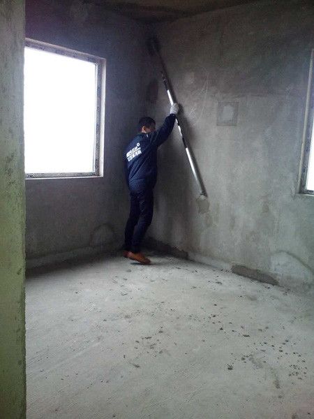 验房师精心测量墙面平整度。